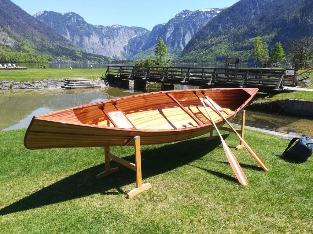 Cedar strip canoe with paddles by a lake in the mountains